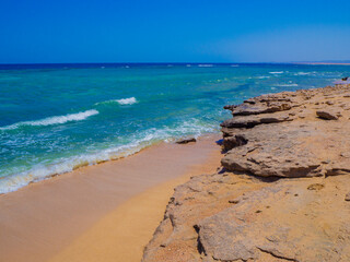 Fototapeta na wymiar Beautiful wild beach with turquoise water, orange sand and coral reef. Egypt, Marsa alam. Red sea