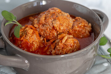 Meat balls on a light background with sage and parsley leaves. Homemade lunch.