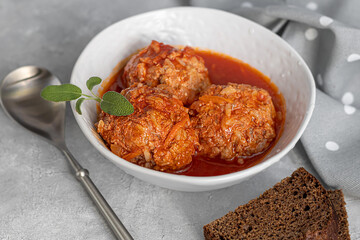 Meat balls on a light background with sage and parsley leaves. Homemade lunch.