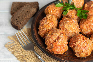 Meat balls on a light background with sage and parsley leaves. Homemade lunch.