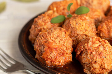 Meat balls on a light background with sage and parsley leaves. Homemade lunch.
