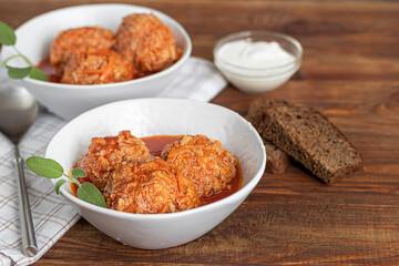 Meat balls on a wooden background with sage and parsley leaves. Homemade lunch.