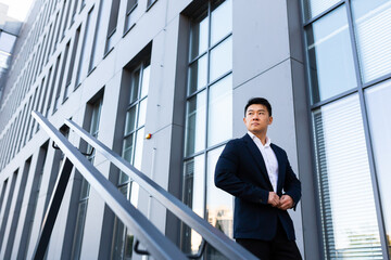 Asian businessman walks up the stairs of the office center, man hurries to a business meeting in a...