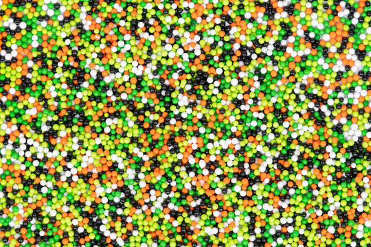 Halloween colored festive sprinkles close up in black, orange, green and white round balls