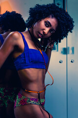 Latin brunette skinned model of Dominican origin posing for portrait, with exercise clothes showing a chunky body with afro hair and fitness body
