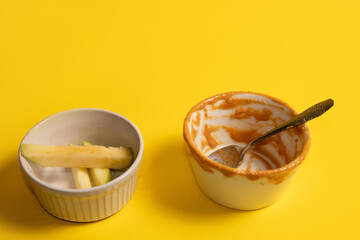 An empty cup of peanut butter and apple slices