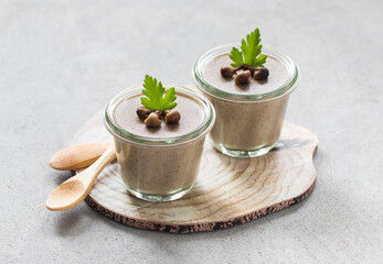Vegan mushroom dish, yellow boletus pudding in glass on a wooden board on a light gray background 