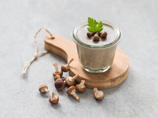 Mushroom dish, yellow boletus pudding in glass on a wooden board on a light gray background