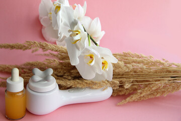 Spa treatments body massager and massage oil on a pink background. anti-cellulite massagers and facial massagers