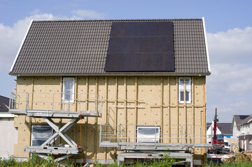 House under construction with a black roof with solar panels