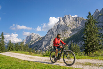 beautiful active senior woman with electric mountainbike in the spectacular Mountains of Raintal...