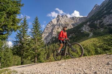 beautiful active senior woman with electric mountainbike in the spectacular Mountains of Raintal Valley, a side valley of Lechtal, Tyrol, Austria