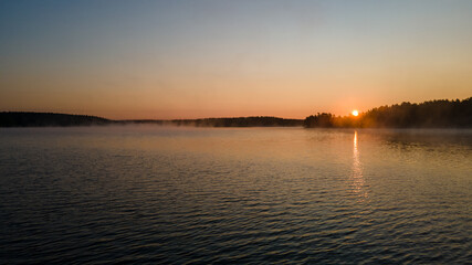 Beautful sunrise on a lake with fog over a forest in Tiveden Nationalpark in Sweden - Drone Perspective Landscape Photography