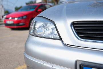 Fototapeta na wymiar Closeup of clean headlights of silvery car in parking