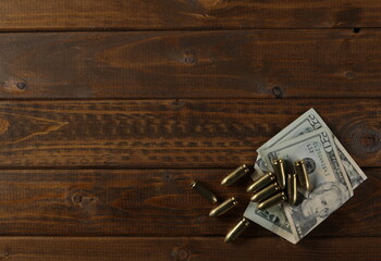Bullets and dollars on wooden planks, table texture, top view