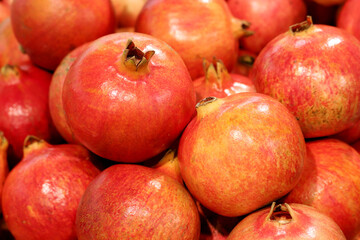 Ripe pomegranates close up, selective focus. Red pomegranate fruits on the market, natural background