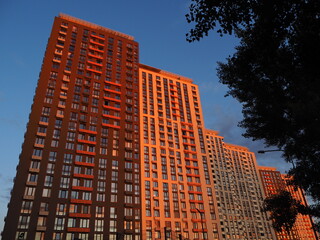 Beautiful orange sunset in the big city. High-rise houses in the sun
light. Ukraine, Kiev (Kyiv) 05.09.2021
