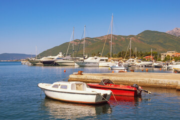 Fototapeta na wymiar Beautiful Mediterranean landscape. Sailboats and fishing boats on water. Montenegro, Adriatic Sea. Kotor Bay near Tivat city on sunny autumn day