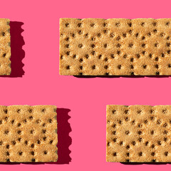 Photo in the form of a seamless pattern. Orange color crisps for healthy food with shadows on a colored pink background.