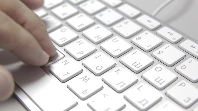 Computer work: Hands are typing on a macbook keyboard. Close-up