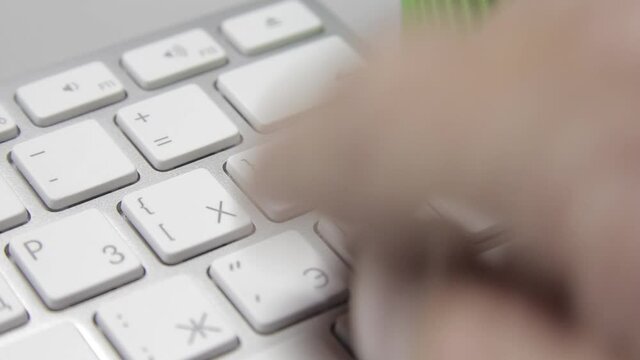 Computer work: Hands are typing on a macbook keyboard. Close-up