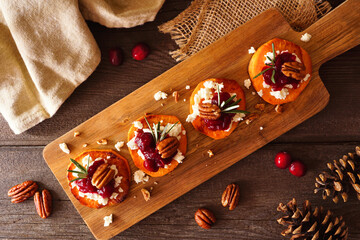 Autumn sweet potato crostini appetizers with cheese, cranberries and pecans. Above view table scene...