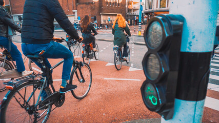 Bikes and bikers are riding in Amsterdam - obrazy, fototapety, plakaty