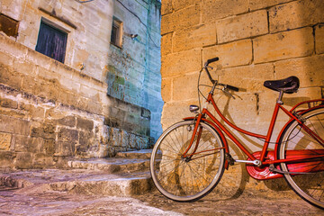 Night urban view of a bicycle by an old building in Matera, Italy