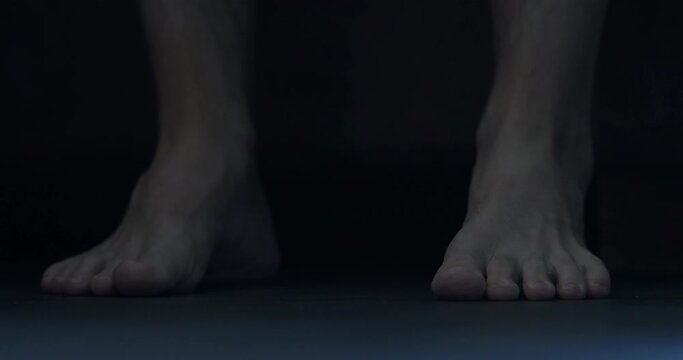Slow motion man put his feet on floor in midnight and walk