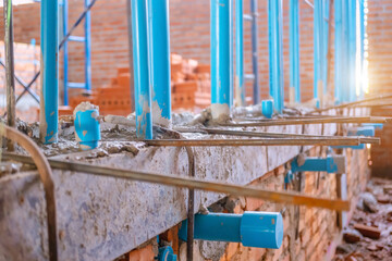 Water supply pipe layout work. Chrome pipes and fittings on brick wall background. Piping with many fittings. Pipes for water supply systems. Concept designing layout of utilities. Fragment of a room.