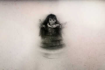 A spooky floating vintage doll set against a textured background. With a blurred, grunge edit