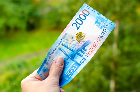 A Russian banknote with a face value of 2000 rubles in the hand of a woman. The concept of finance, investment, savings and cash.