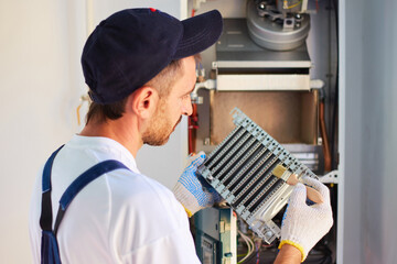 The master performs work on repair and cleaning of the gas boiler. Disassembly and assembly of the burner.