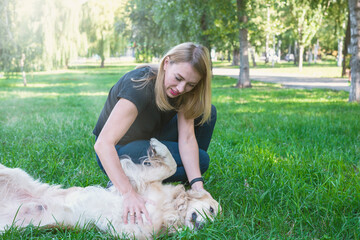  girl playing with a dog of breed golden retriever in the park