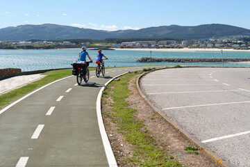 Cyclists riding on a bike path with the sea in the background