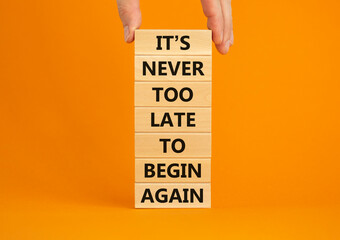Begin again symbol. Wooden blocks with words 'It is never too late to begin again'. Businessman...