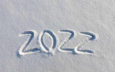 the inscription about the new year 2022 on the snow in winter