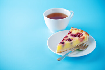 Fresh sweet cheesecake with cherries and almond sprinkles in a plate