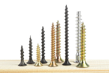 Industry concept - black and golden screws on wooden board isolated on a white background.