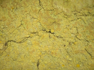 Texture of yellow cracked clay rock. Clay walls with cracks.