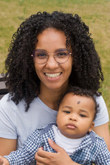 Young beautiful dark-skinned mother holds her baby in a hands