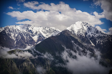 Fototapeta na wymiar Mountain Ridge with Snow-Capped Peaks at North Ossetia. Caucasus Range