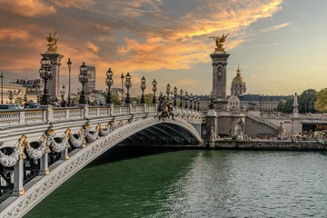 Photo sur Plexiglas Pont Alexandre III Coucher de soleil sur le pont Alexandre III à Paris et avec le palais des invalides en arrière plan