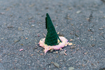 Ice cream cone in a glass cup for a children's birthday party with colorful decor and sweets with a blurred background.