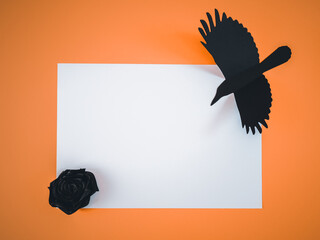 White sheet of paper with black crow on orange.