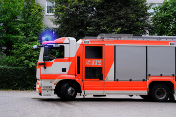 red fire truck in the courtyard of a multi-storey building arrives on call, emergency 112 concept...