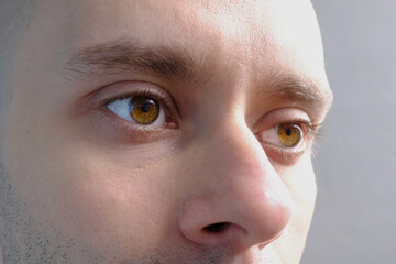 close up part of the man's face, man 30-35 years old, human eye looking to the side, the concept of...