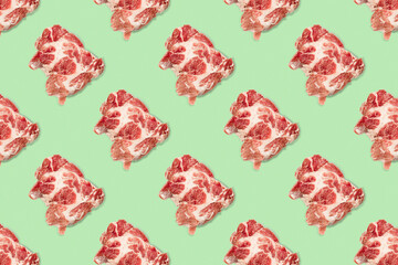 Seamless food pattern with raw pork meat slices on green background, beef steaks. top view. Food flatly flat lay