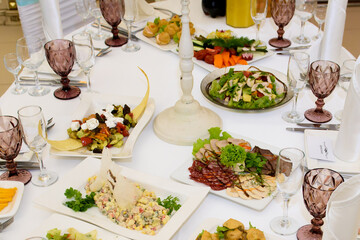 A table with food dishes in the restaurant. Festive food in the reception room.