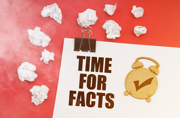 On a red background in smoke, crumpled paper and a sheet with the inscription - TIME FOR FACTS